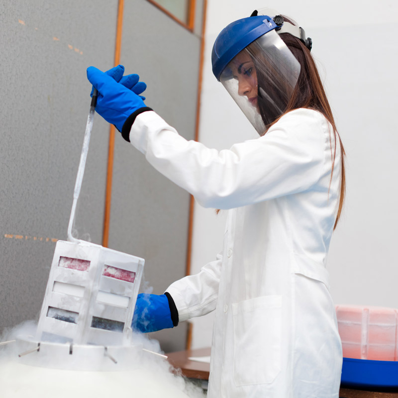 A woman working in a lab, handling a nitrogen tank
