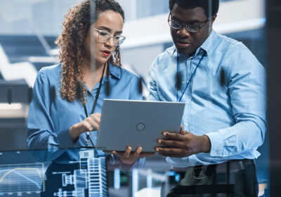 Image of two technicians looking at a laptop