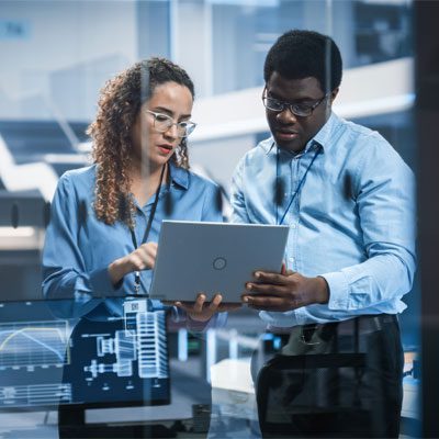 Image of two technicians looking at a laptop